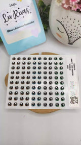Sheet of black and white stickers with a decorative border on a white surface.